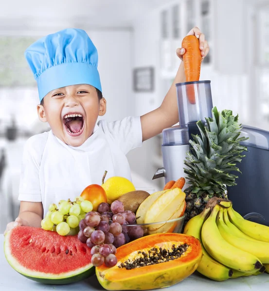 Pequeno chef está fazendo suco de frutas — Fotografia de Stock