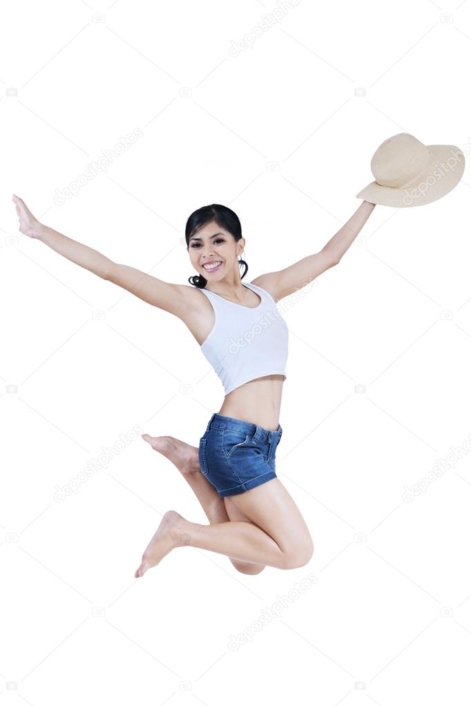 Beautiful girl jumping with hat