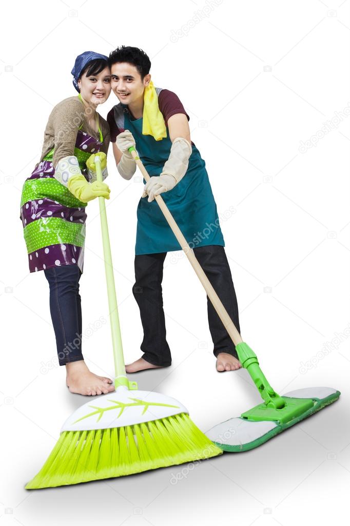 Happy couple cleaning the floor isolated