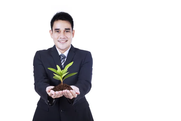 Geïsoleerde zakenman bezit een plant — Stockfoto