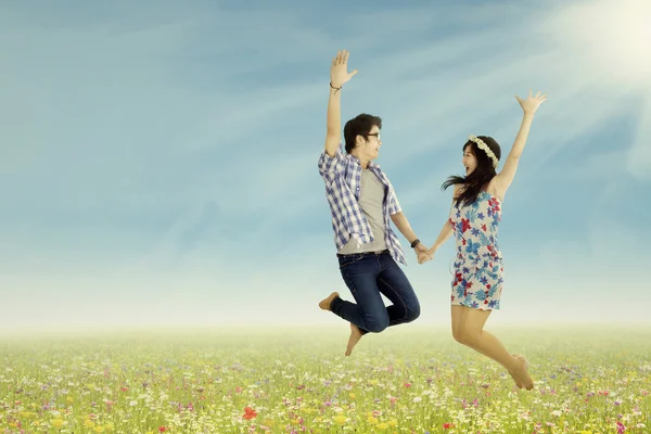 A lovely young couple jumping — Stock Photo, Image