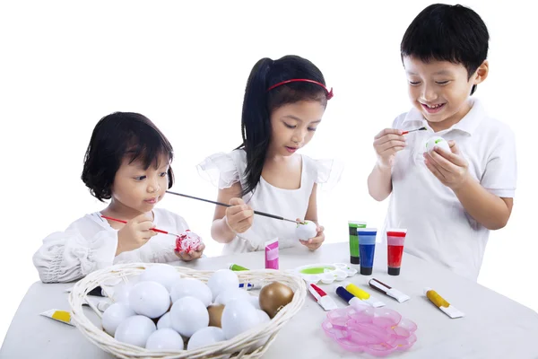 Дети раскрашивают пасхальные яйца — стоковое фото