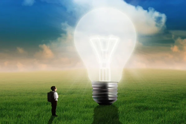 Little boy looking at big light bulb — Stock Photo, Image