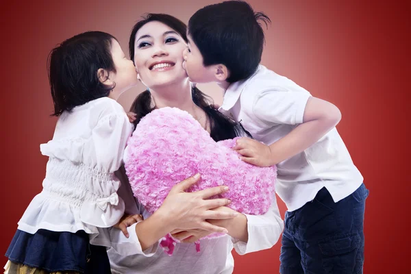 Mãe feliz beijada por crianças — Fotografia de Stock