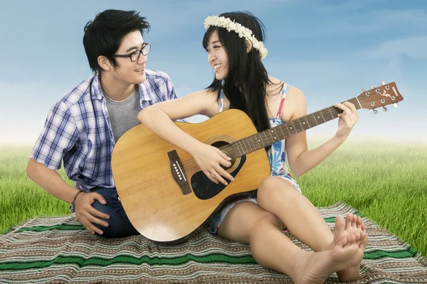 Pareja romántica tocando la guitarra juntos — Foto de Stock