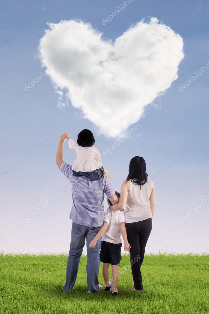 Family looking at heart clouds