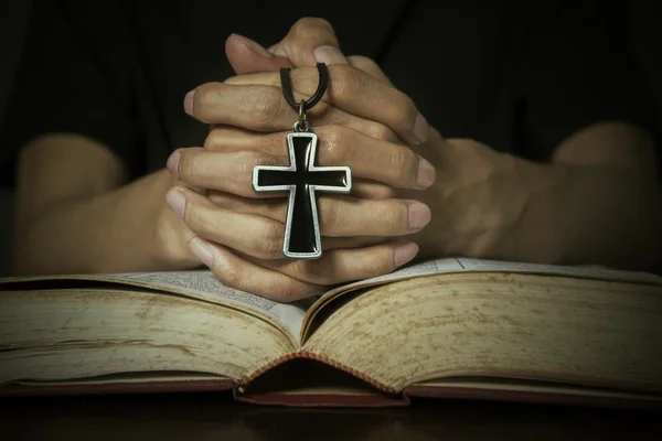 Bijbel en handen met een rozenkrans — Stockfoto