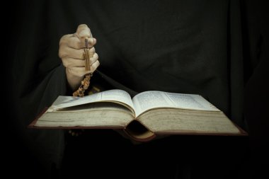 İncil ve tespih tutan eller