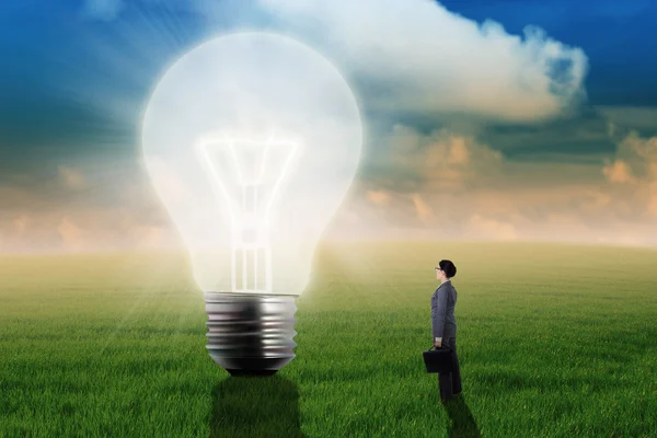 Businesswoman Looking At Big Light Bulb — Stock Photo, Image