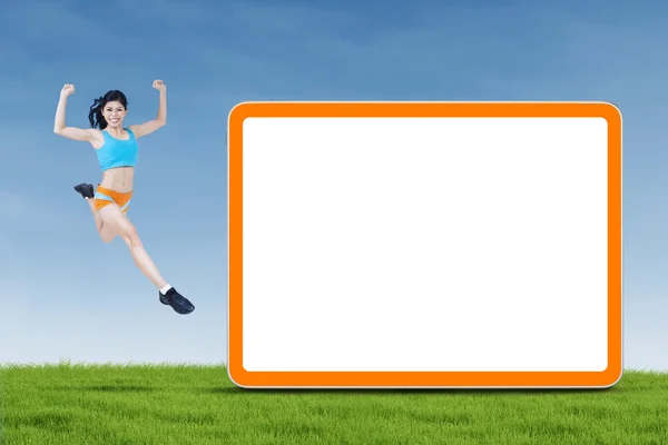 Healthy woman jumping next to copyspace — Stock Photo, Image