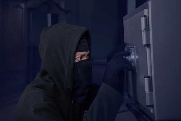 Um ladrão a tentar abrir uma caixa de segurança — Fotografia de Stock