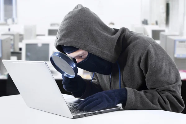Hacker op zoek naar informatie op kantoor — Stockfoto