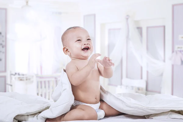 Adorable baby laughing in the bedroom — Stockfoto