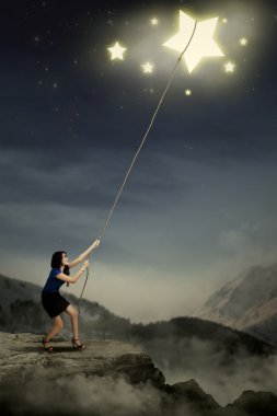Young woman pulling bright stars clipart