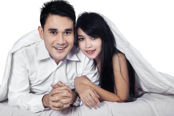 Happy couple hiding under blanket — Stock Photo, Image