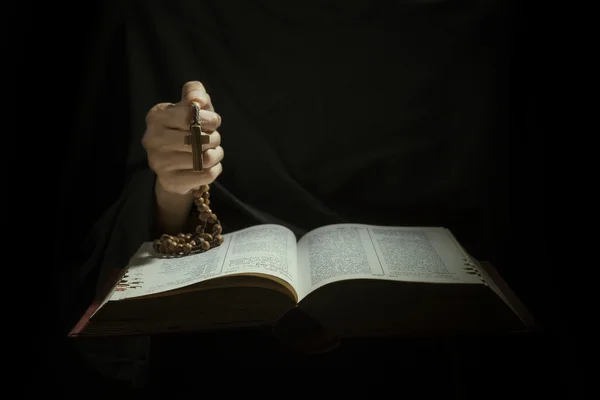 Santa Bibbia aperta con una croce su una mano — Foto Stock