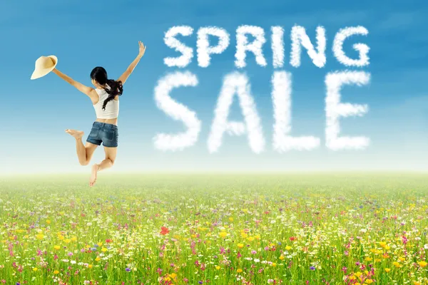 A girl jumping with spring sale clouds — Stock Photo, Image