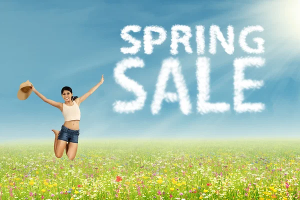 Woman jumps with spring sale sign — Stock Photo, Image