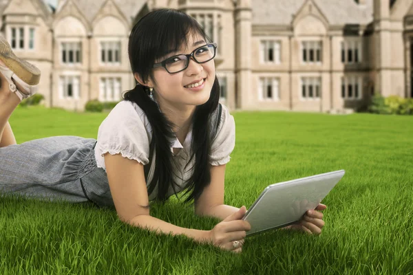 Estudante atraente segurando um tablet digital ao ar livre — Fotografia de Stock