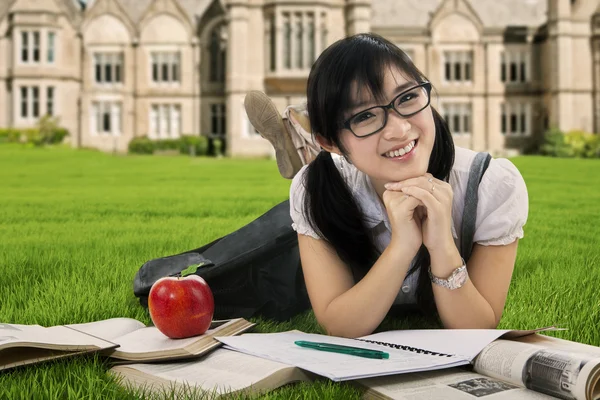 Cheerful female student lying on grass — Stock Photo, Image