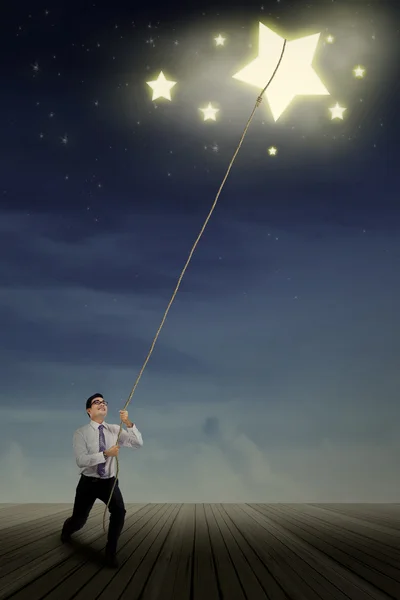 Businessman pulling stars — Stock Photo, Image