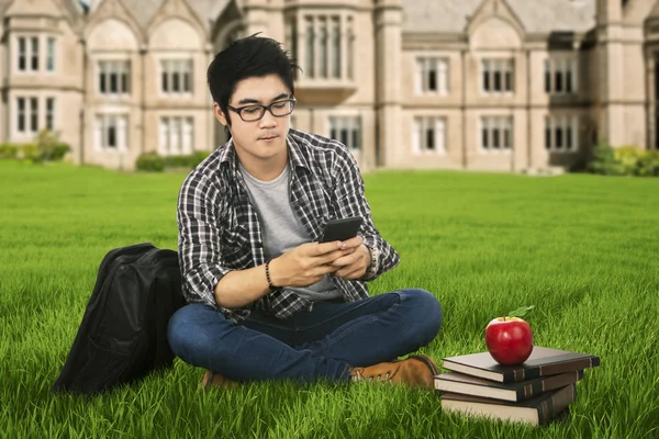 Mannelijke student met mobilephone buiten — Stockfoto