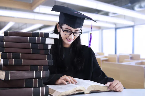 Um diploma está lendo livros na sala de leitura — Fotografia de Stock
