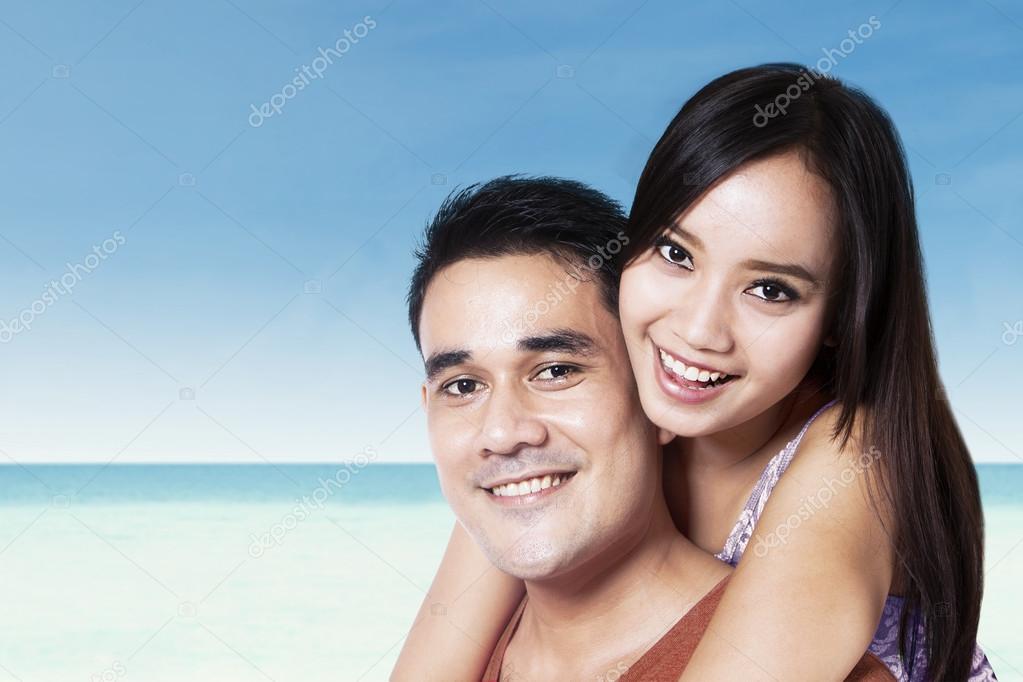 Young couple piggyback at beach