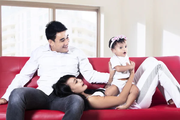 Família feliz jogando no sofá — Fotografia de Stock