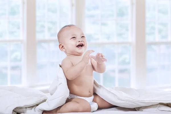 Bebé riendo en el dormitorio — Foto de Stock