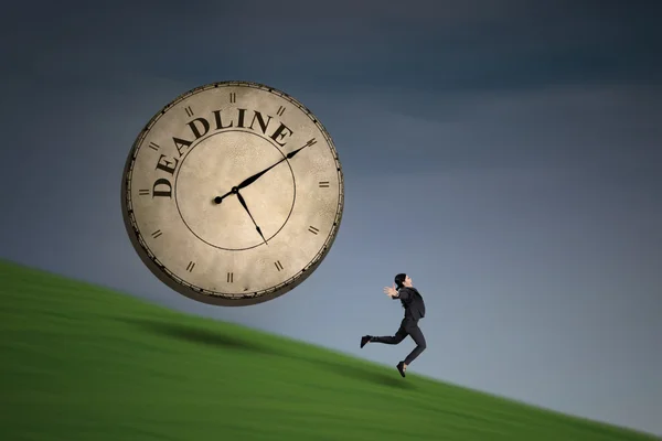 Empresaria corriendo con un reloj de plazo — Foto de Stock