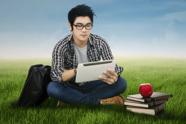 Mannelijke student met behulp van digitale tablet buitenshuis — Stockfoto