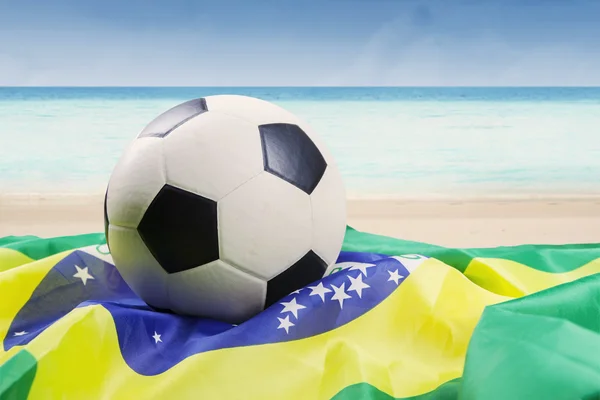 Pallone da calcio sopra la bandiera brasiliana — Foto Stock