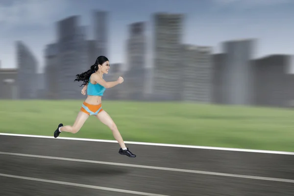 Mujer atlética corriendo en pista — Foto de Stock