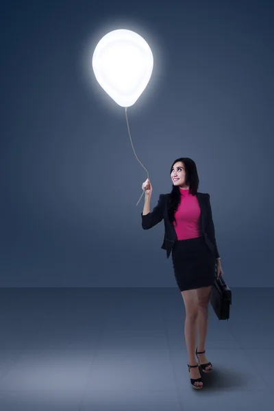 Businesswoman holding bulb balloon — Stock Photo, Image