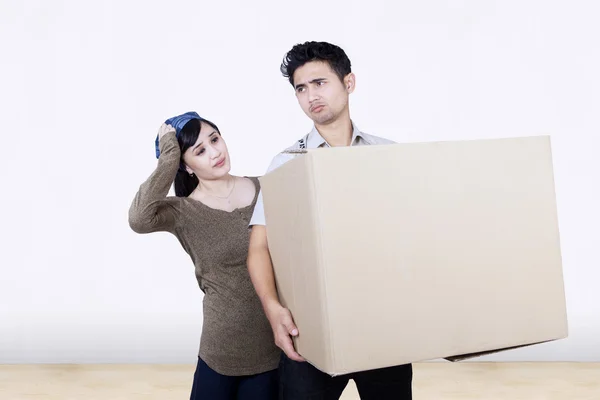 Confundida pareja traer caja en nuevo hogar — Foto de Stock
