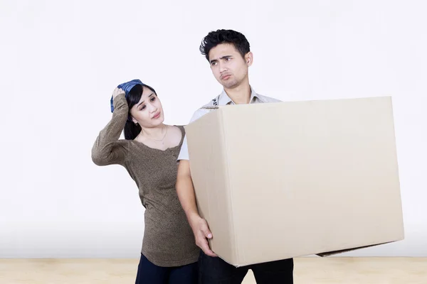 Confused couple bring box at new home — Stock Photo, Image