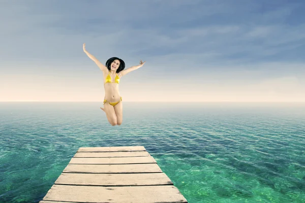 Donna felice che salta sul molo — Foto Stock
