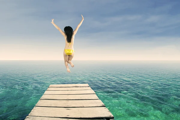 Szczęśliwa kobieta skoki na molo 1 — Zdjęcie stockowe