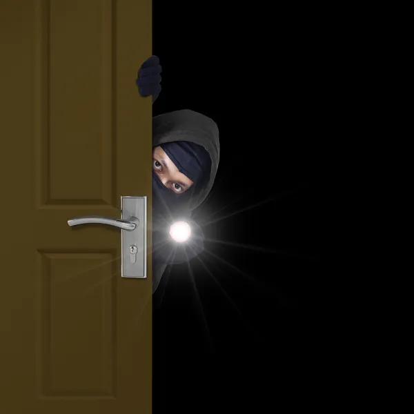 Burglar sneaking through door