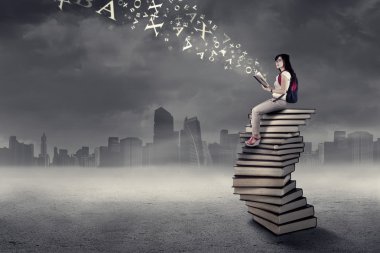 bir kitap 1 yığını üzerinde oturan öğrenci