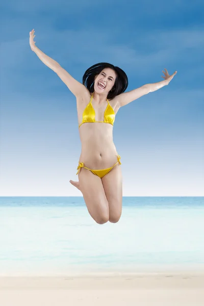 有魅力的女人，穿比基尼在海滩上跳跃 — 图库照片