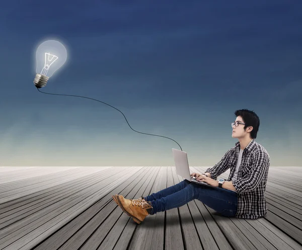 College student with laptop and ligthbulb — Stock Photo, Image