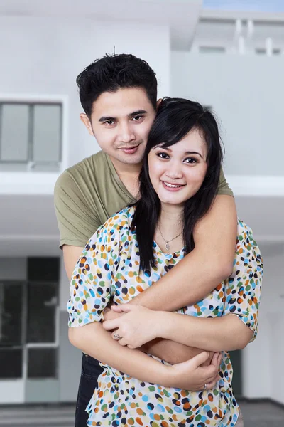 Casal feliz na frente de sua nova casa — Fotografia de Stock