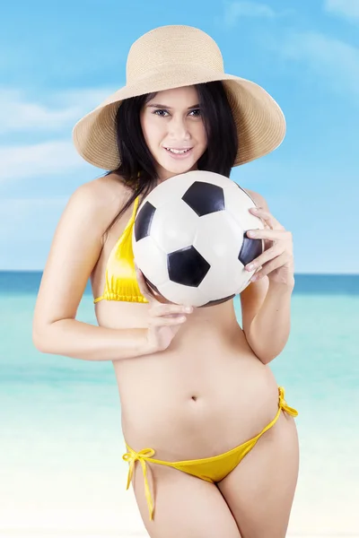 Modello sexy che tiene un pallone da calcio in spiaggia — Foto Stock