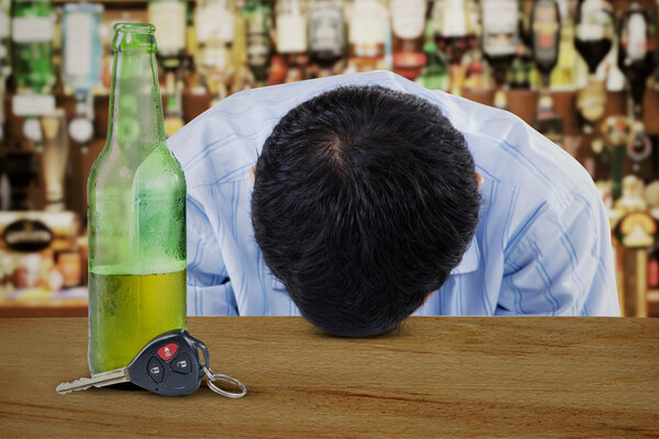 Молодой алкоголик в баре
