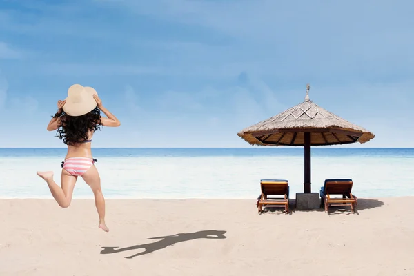 Vrouw in gestreepte bikini uitgevoerd op strand — Stockfoto