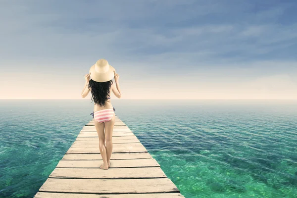 Woman wearing striped bikini standing at pier — Stock Photo, Image