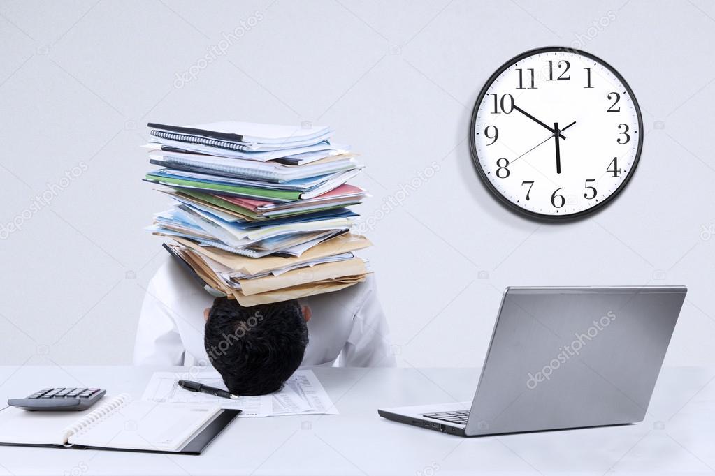 Overworked businessman with documents on his head