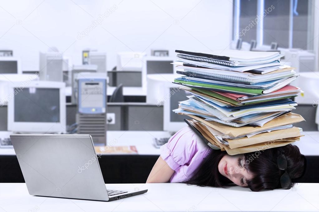 Overworked businesswoman with documents